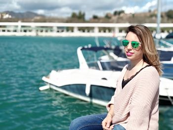 Portrait of smiling young woman against sea