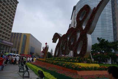 Group of people on building against cloudy sky