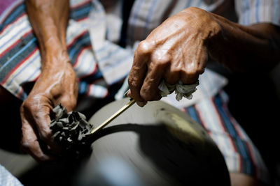 Midsection of man making pottery