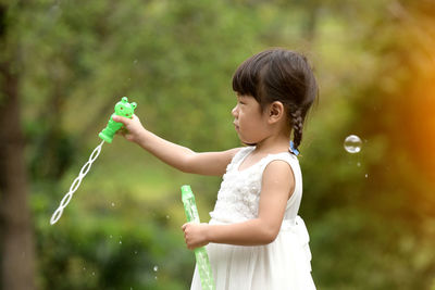 Girl playing with bubbles in water