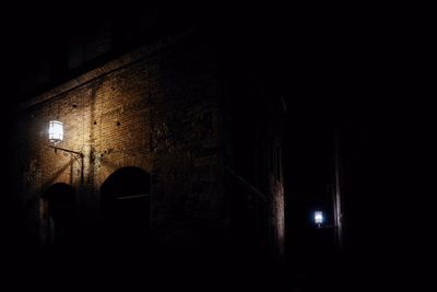 Silhouette man standing against old building at night