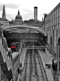 Railroad tracks in city against sky