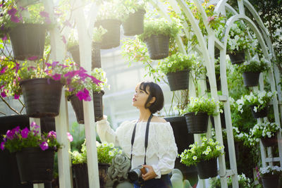 Young woman looking at potted plant at market stall