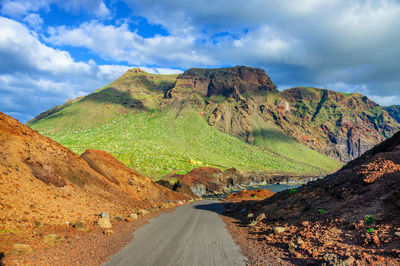 Scenic view of road amidst mountains against sky