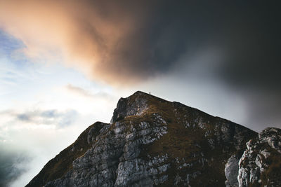 Low angle view of mountain against cloudy sky