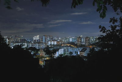 Aerial view of illuminated buildings against sky at night