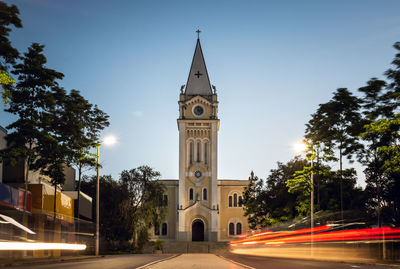 Light trails on building against sky in city