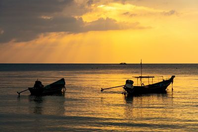 Boat in sea against sky during sunset