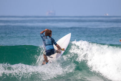 Man surfing in sea against sky