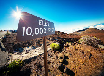 Information sign on landscape against sky