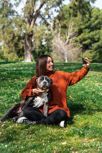 Woman taking selfie with dog at park