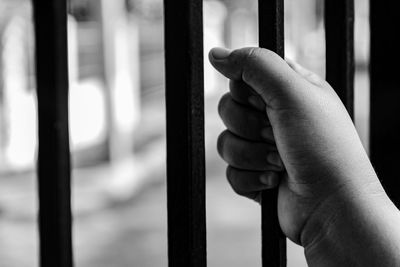 Cropped hand of person holding metal in prison