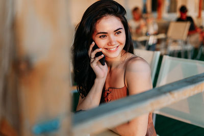 Portrait of smiling young woman using mobile phone