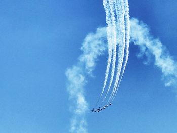 Low angle view of airshow against blue sky