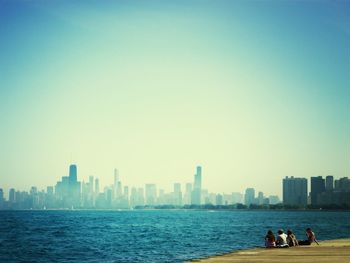 People relaxing by lake michigan