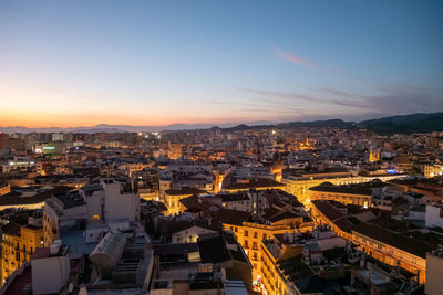 High angle view of illuminated buildings against sky during sunset