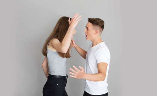 Side view of young couple against white background