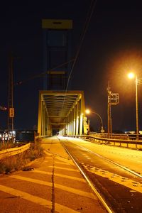 Illuminated light trails on road in city against sky at night