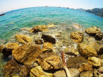 Close-up of rocks in sea against sky