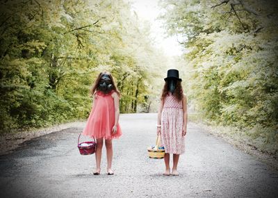 Front facing of sisters walking on road along trees. it was a quarantine easter in oklahoma. 
