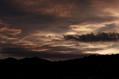 Silhouette of trees against dramatic sky