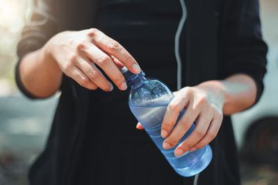 Close-up of woman hand holding glass bottle