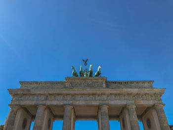 Low angle view of statue against blue sky