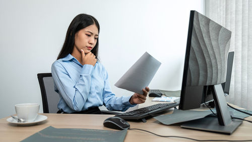 Thoughtful woman looking at business report