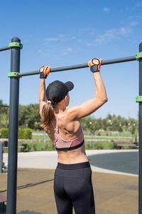 Rear view of woman with arms raised