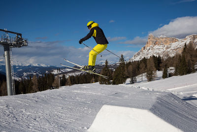 Man skiing on snowcapped mountain against sky