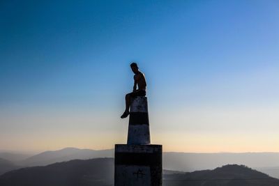 Silhouette statue against clear sky during sunset