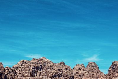 Low angle view of rocks against blue sky