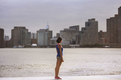 Woman looking at buildings while standing on promenade