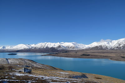 Scenic view of snowcapped mountains against clear blue sky