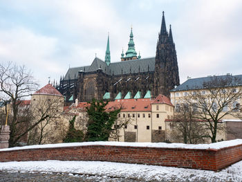 Snowy prague city with gothic castle and colorful trees, czech republic. winter evening mood