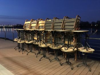 Chairs and tables in sea against clear sky