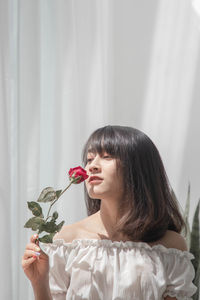 Portrait of a beautiful young woman holding flower