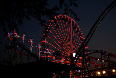 Low angle view of illuminated ferris wheel at night