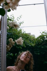 Portrait of woman holding flowering plants