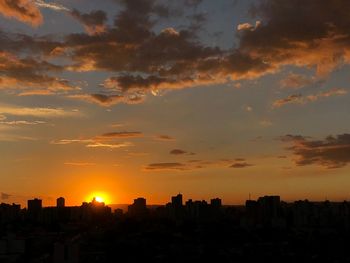 Silhouette buildings against sky during sunset