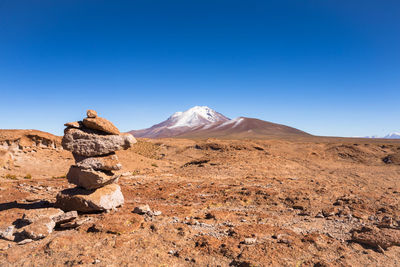 Scenic view of arid landscape against clear blue sky