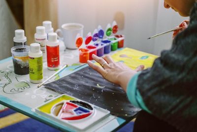 Midsection of woman painting on table