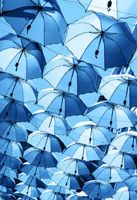 Low angle view of umbrellas against blue sky