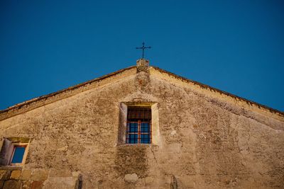 Low angle view of old building against clear blue sky