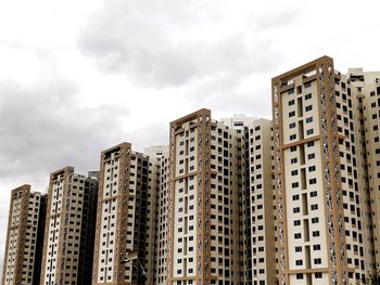 Low angle view of buildings against cloudy sky