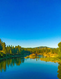 Scenic view of lake against clear blue sky