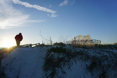 Man on beach against sky during winter