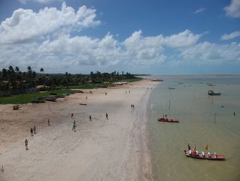 People at beach against sky