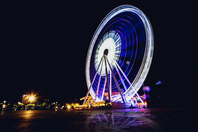 Illuminated ferris wheel at night