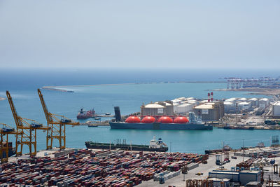 Boats moored at harbor against sky